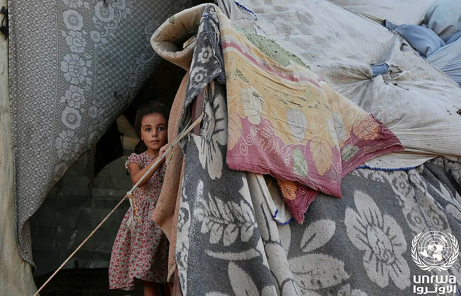 Una niña desplazada frente a su tienda en Deir al-Balah