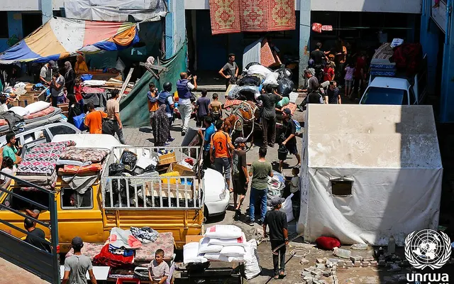 Vertriebene Palästinenser mit ihrem Hab und Gut und Hilfssäcken in einer UNRWA-Schule in Deir al-Balah